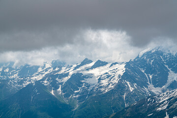 Obraz premium Majestic Snow-Capped Mountains Under a Brooding Sky at Midday