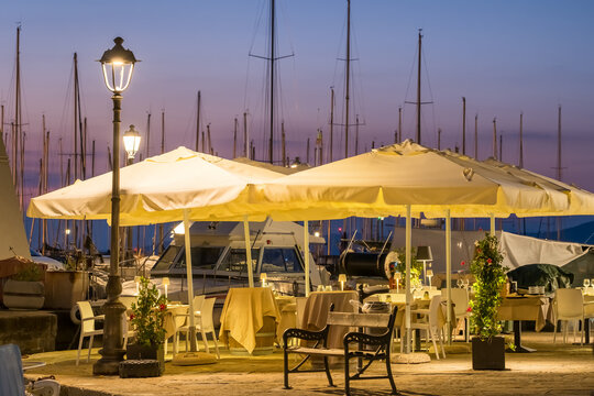 Cozy outdoor restaurant in the picturesque marina of Muggia old town, near Trieste, Italy