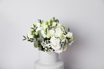 Wedding bouquet of beautiful flowers in vase against grey wall, closeup