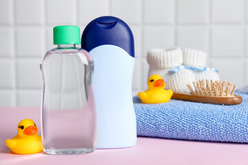 Baby oil and bath accessories on pink table
