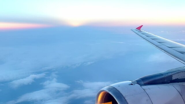 Airplane Wing Above the Clouds at Sunrise, Aerial Travel View