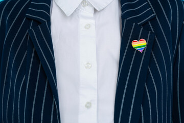 Woman with heart shaped pin in LGBT colors, closeup