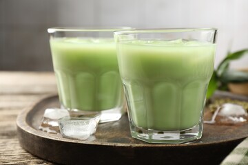 Fresh mung bean juice with ice in glasses on wooden table, closeup