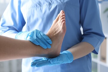 Doctor examining patient's foot in hospital, closeup