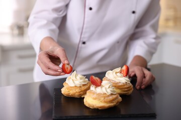 Professional pastry chef making desserts at table in kitchen, closeup