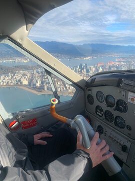 Close-up of a pilot in a private plane flying over the coast of Vancouver, British Columbia, Canada