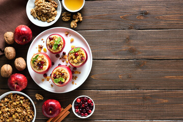 Stuffed apples with granola, cranberries, nuts and honey on plate