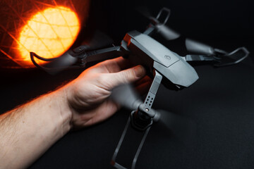 quadcopter in a dark room illuminated by red light in a person's hand simulation of flight and launch in the hand	