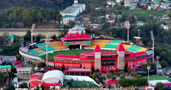 An aerial pan from left to right captures the vibrant Dharamshala Cricket Stadium, nestled in Himachal Pradesh&mdash;renowned as the most beautiful stadium in the world.