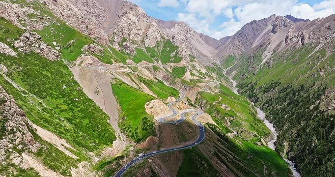 Winding mountain road through a scenic valley landscape. Spectacular Duku Highway natural scenery in Xinjiang, China.