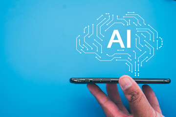 Smartphone held with AI brain circuit design above on blue background with copyspace idea for...