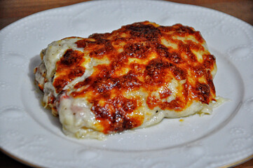 Chicken baked with bechamel sauce on plate
