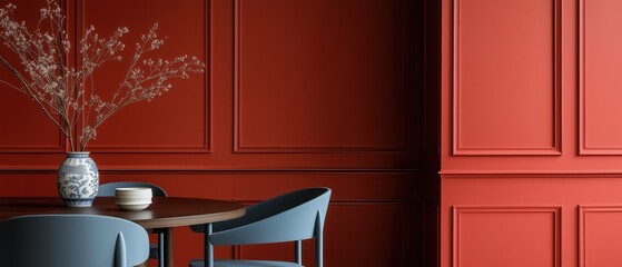Dining room with a wooden table and two blue chairs. the walls are painted in a deep red color and have a paneled design on the right side.