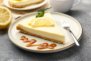Piece of delicious lemon cheesecake served on grey textured table, closeup
