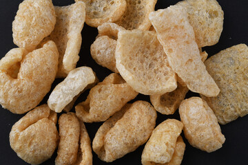 チチャロン　メキシコやフィリピンで食べられる豚の皮（豚皮）のスナック　黒背景 Chicharon　(chicharrón, chicharron), pork skin (pig skin) snack, eaten in Mexico and the Philippines, black background