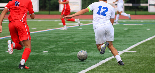 Player in White Jersey Makes a Strategic Play During a Soccer Match on a Well-Maintained Field
