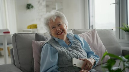 Video of senior woman sitting on sofa and texting. Elderly people using smartphones.