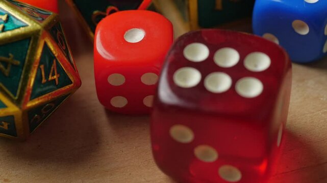 A close-up shot of various polyhedral dice, used in tabletop role-playing games. The dice are in different colors and sizes, showcasing the variety used for gaming