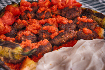 Meatballs (kofta) with yogurt, tomato sauce and pide (pita).
