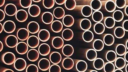 A row of pipes with a brownish color. The pipes are stacked on top of each other. industrial concept background