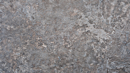 Gray stone wall with rough texture as a background for a template or banner. The wall is made of stone and has a gray color