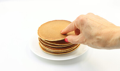Woman's hand picking pancakes for breakfast.