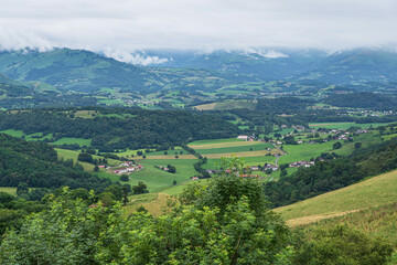 Rural landscape in the Pyrenees in France with fields, forest and mountains