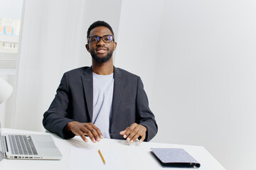 Business professional working on laptop and taking notes at office desk