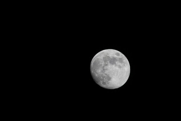 Beautiful full moon on a black background wallpaper. Beautiful full moon in a dark night. Moon wallpaper. Moon background 