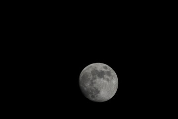 Beautiful full moon on a black background wallpaper. Beautiful full moon in a dark night. Moon wallpaper. Moon background 