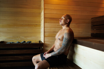 Muscular african american man relaxing in steam room in spa center