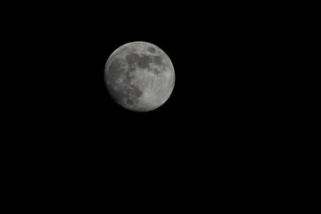 Beautiful full moon on a black background wallpaper. Beautiful full moon in a dark night. Moon wallpaper. Moon background 