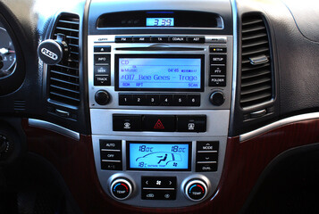 Old car multimedia system on dashboard. SUV control panel. Classic Vehicle Conditioner and climate control. Radio on control panel system in car. Multimedia control system.