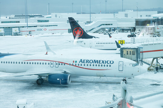 Snow-covered tarmac at Vancouver International Airport showing AeroMexico aircraft in foreground