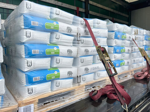Germany - 03.02.2025: Truck semitrailer with bags of Caparol building mixtures on pallets