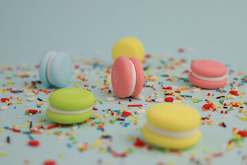 on a light background bright macaroons and small multi-colored sprinkles decor for Easter cakes and other desserts