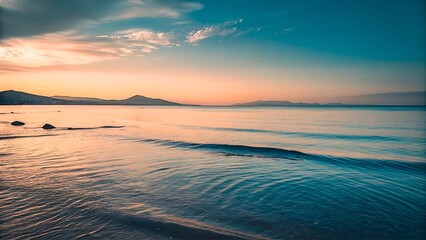 Obraz premium A serene image of a calm azure sea at dusk with a gentle wave rolling in.