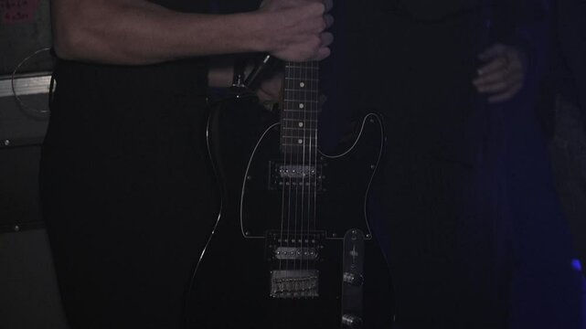 Musician holding guitar backstage before going on stage