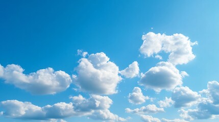 Naklejka premium Fluffy clouds drifting in vibrant blue sky, serene atmosphere, perfect for relaxation, ideal for nature themes and tranquility.