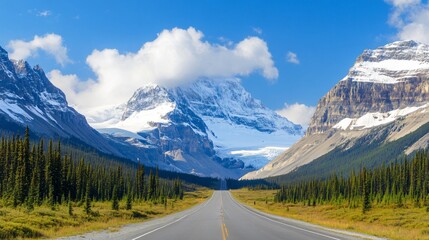 Fototapeta premium Expansive mountain landscape with clear blue sky, serene road cutting through lush green valley, ideal for travel inspiration.