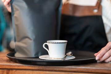 Close-up of a barista woman making a fresh and aromatic Americano coffee with professional technique