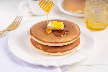 Pancakes with butter and honey or maple syrup drizzles