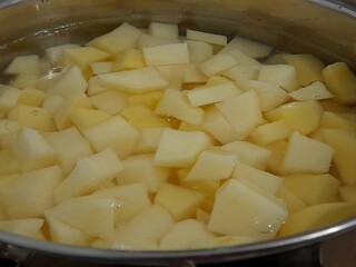 Diced raw potato in water in cooking pan