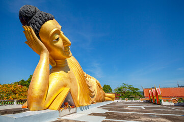 Lying golden Buddha statue in Wat Sri Sunthon temple on Phuket in Thailand. Gilded Buddha statue in...