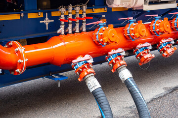 An industrial fluid distribution system with bright orange pipes, multiple valves, and connected...