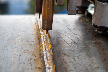 the metalworking and welding industry, an automated welding machine is creating a strong weld seam on a steel surface, ensuring structural integrity and durability