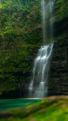 Fototapeta premium Vertical Shot of Marimbondo Waterfall Surrounded by Greenery vertical shot, Marimbondo Waterfall, Brazil, Chapada dos Guimarães, silky water, long exposure, nature, ND filter, waterfall phot