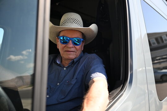 long haul van cargo driver with sunglasses and a cowboy hat on