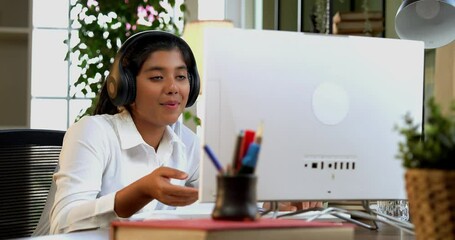 Indian Asian teenage school girl studying online at home using laptop, desktop PC, tablet in a cozy lavish home, focused on education, homework, exam preparation with modern technology in study area