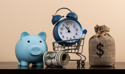 Money bag with US dollar symbol, piggy bank, alarm clock and US$1 bills